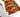 Spicy Korean pork tacos in soft tortillas, topped with green onions and sesame seeds, served in a white takeout container