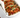 Spicy Korean pork tacos in soft tortillas, topped with green onions and sesame seeds, served in a white takeout container