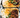 Two halves of a beef galbi burrito filled with Korean BBQ beef, rice, kimchi, and green vegetables, served on foil